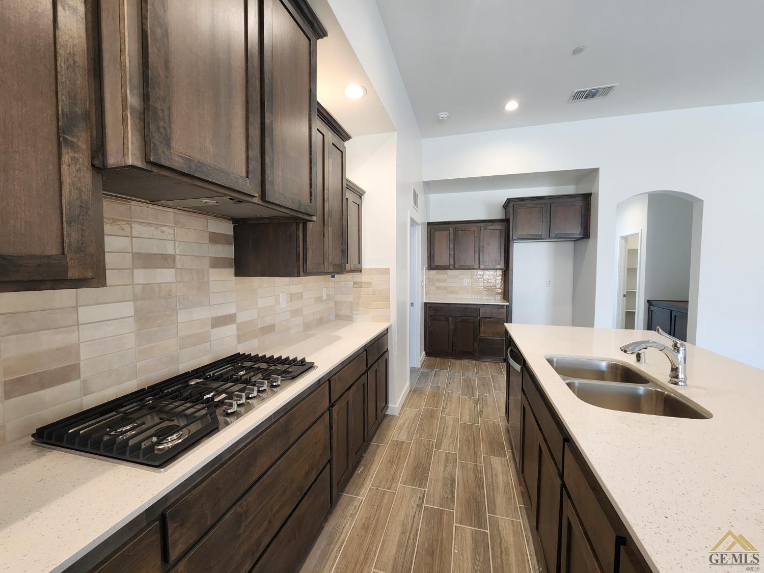 Undisclosed Address Bakersfield, CA 93313 - Photo 6 of 22 a kitchen with granite countertop a sink stove and cabinets