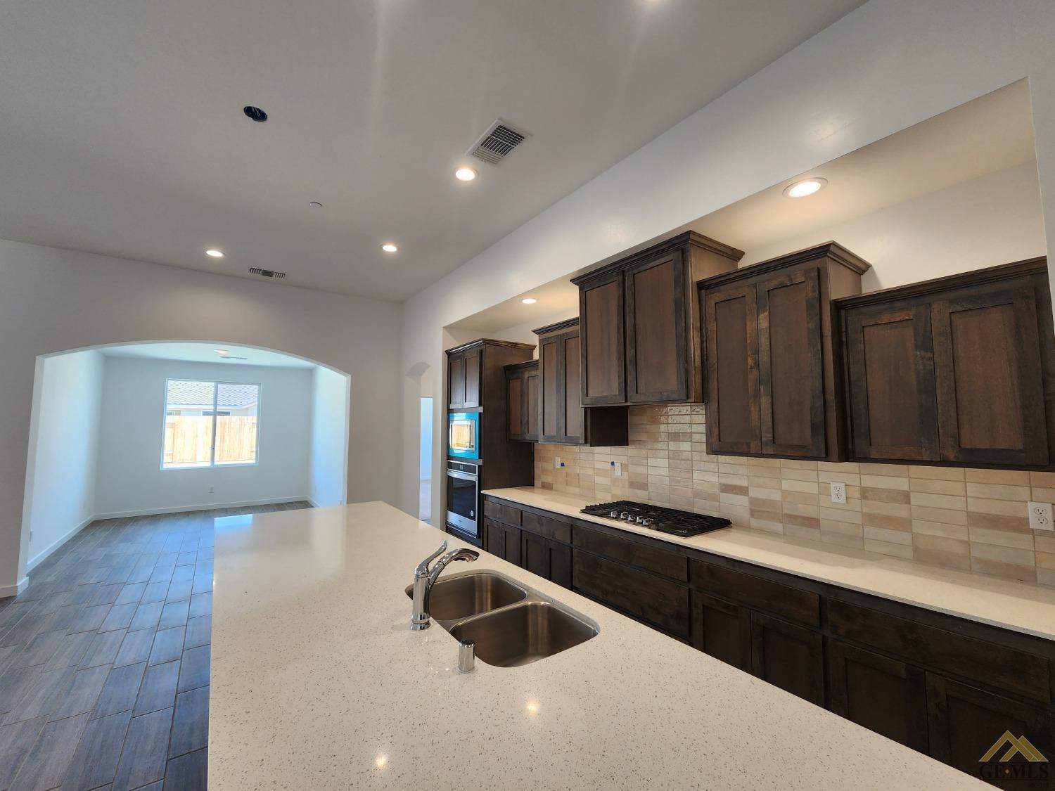 Undisclosed Address Bakersfield, CA 93313 - Photo 7 of 22 a kitchen with kitchen island granite countertop a sink stainless steel appliances and cabinets