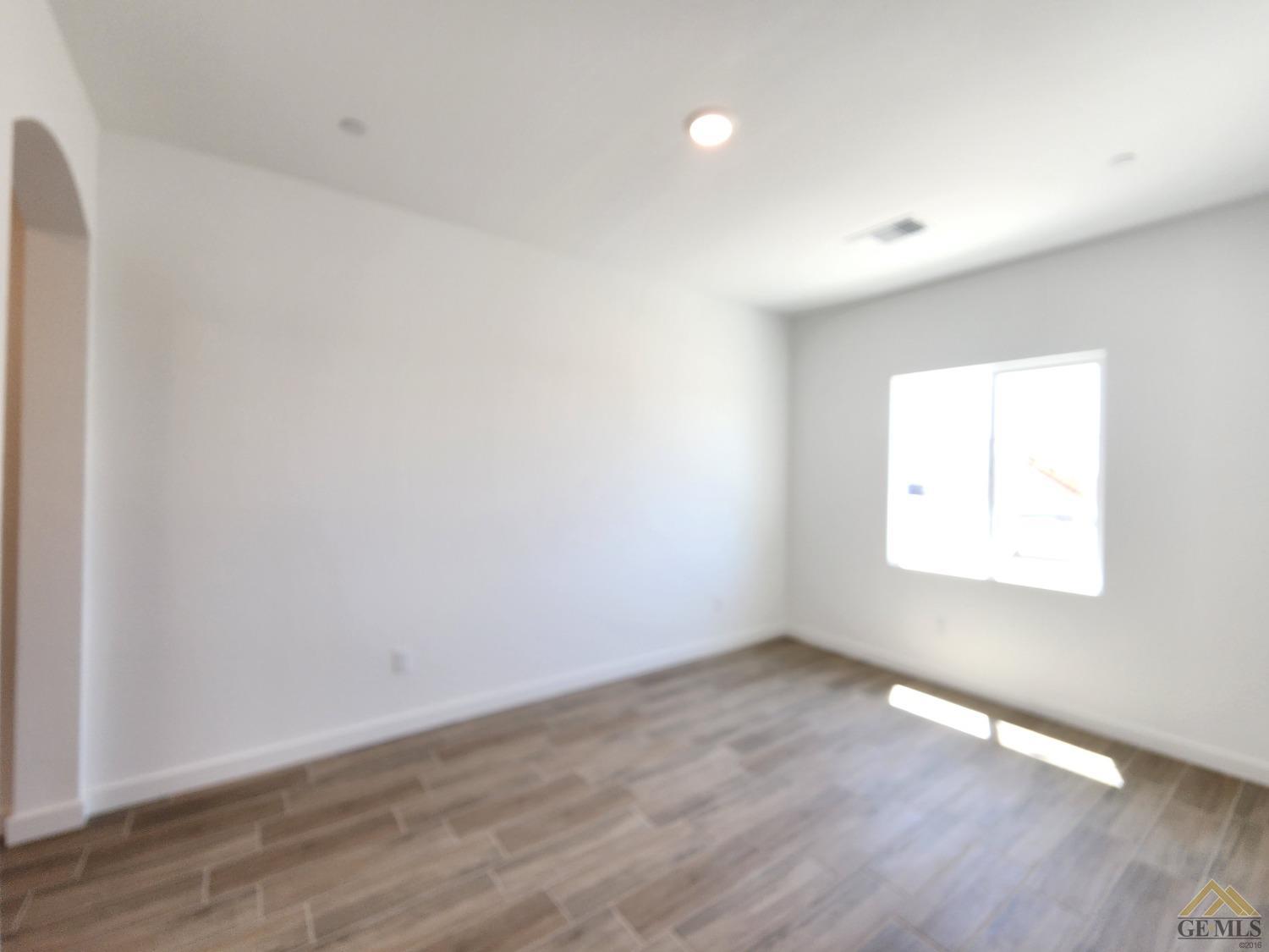 Undisclosed Address Bakersfield, CA 93313 - Photo 9 of 22 an empty room with wooden floor and windows