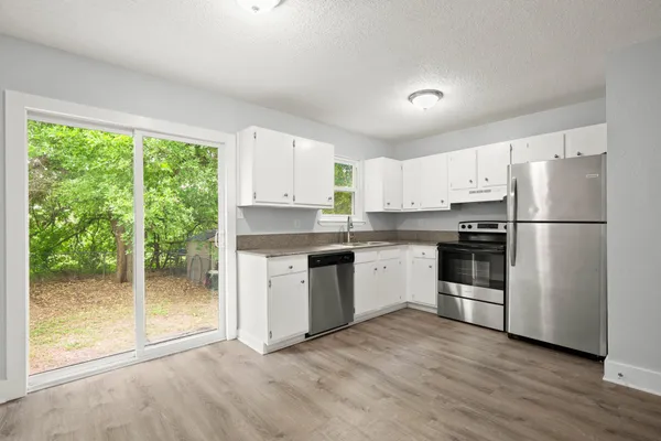 a kitchen with white cabinets and white appliances