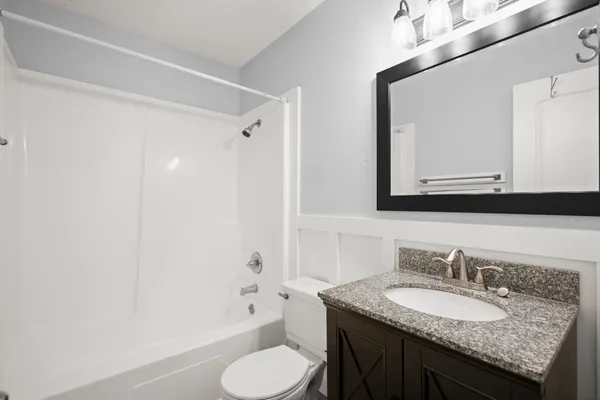a bathroom with a granite countertop sink toilet and shower