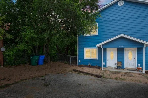 a view of a house with backyard and a tree