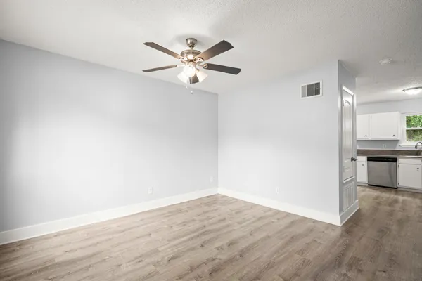 a view of a kitchen with wooden floor and a ceiling fan