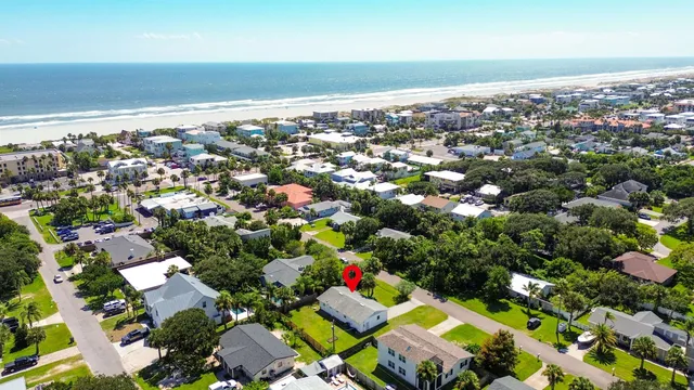 an aerial view of a city with lots of residential buildings and ocean view in back