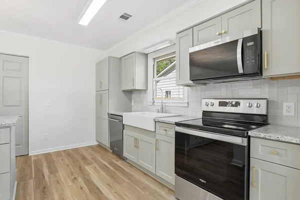 a kitchen with white cabinets stainless steel appliances and sink