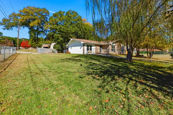a view of a house with backyard and trees