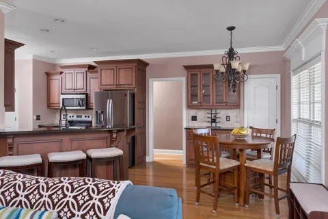 a kitchen with stainless steel appliances wooden floor dining table and chairs