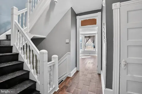 a view of a hallway with wooden floor and entryway