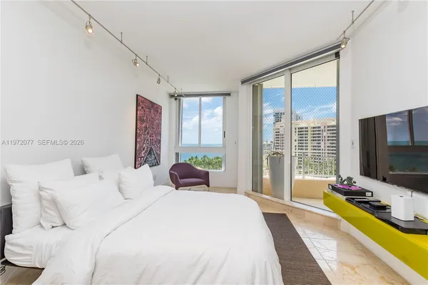 a bedroom with bed tv and window