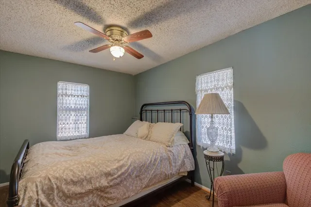a view of a swimming pool with a lounge chair and trees in the background