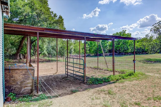 a view of a dining room with furniture a chandelier and large windows