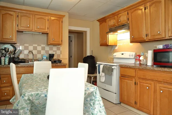 a kitchen with stainless steel appliances granite countertop a stove a sink dishwasher and white cabinets with wooden floor