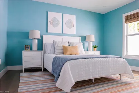 a bedroom with a bed and a lamp on dresser