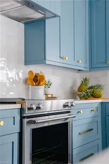 a kitchen with stainless steel appliances granite countertop a refrigerator a microwave a stove and white cabinets