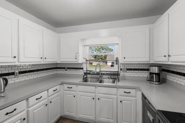 a kitchen with stainless steel appliances granite countertop white cabinets sink and dishwasher