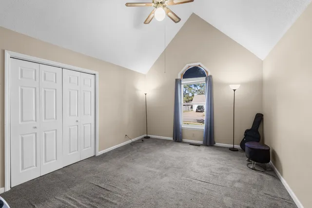an empty room with a window and a ceiling fan