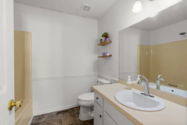 a spacious bathroom with a granite countertop sink mirror and shower