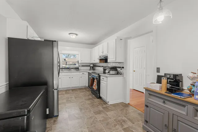 a kitchen with white cabinets and white appliances