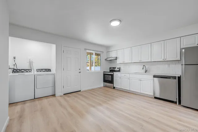 a kitchen with white cabinets and white appliances