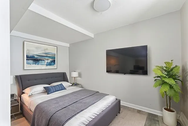 a bedroom with a bed and a flat screen tv