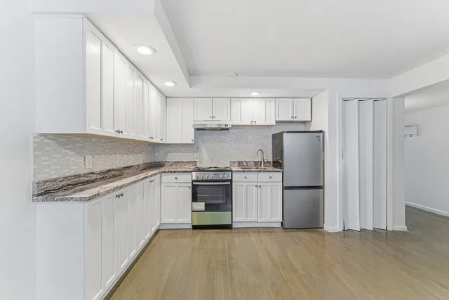 a kitchen with a refrigerator sink and cabinets