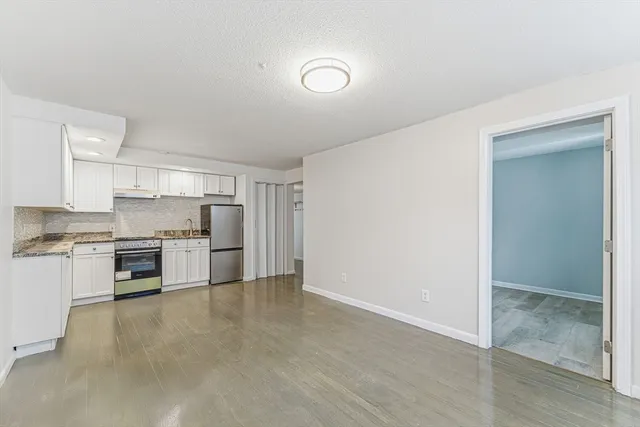 a kitchen with a refrigerator and white cabinets