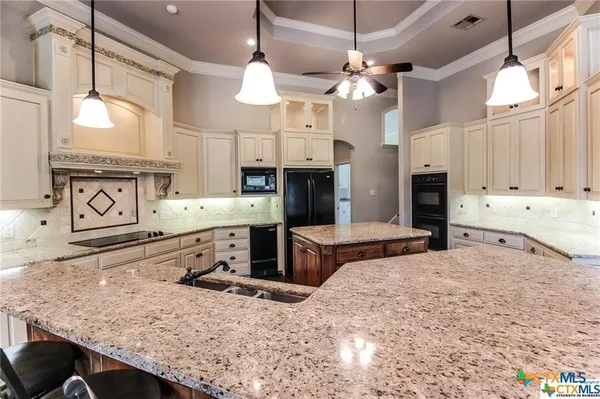 a kitchen with stainless steel appliances kitchen island granite countertop a stove and cabinets