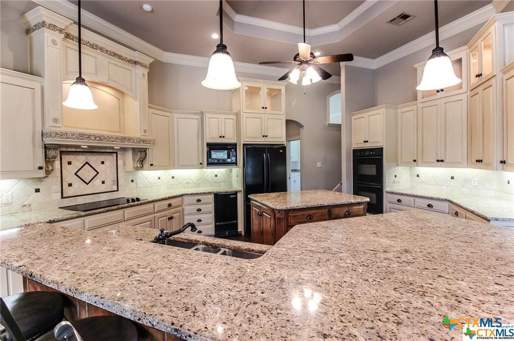 10286 Hartrick Bluff Road Temple, TX 76502 - Photo 23 of 46 a kitchen with stainless steel appliances kitchen island granite countertop a stove and cabinets