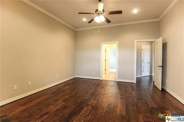 an empty room with a chandelier fan and closet area