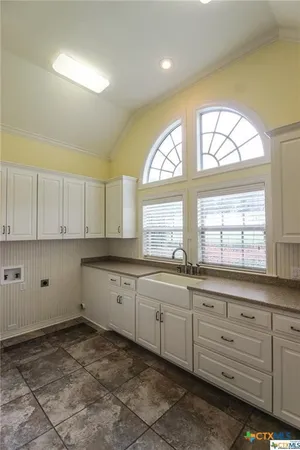 a view of an empty room and window and chandelier fan