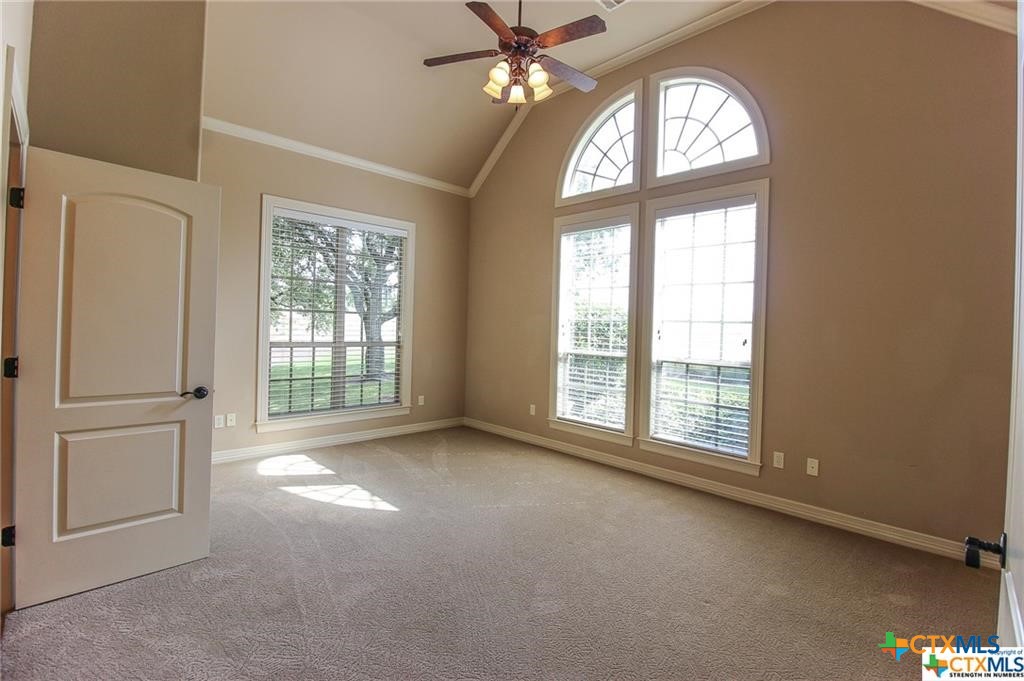 10286 Hartrick Bluff Road Temple, TX 76502 - Photo 42 of 46 an empty room with windows and chandelier fan