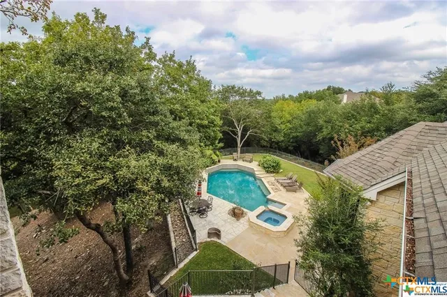 an aerial view of a house with swimming pool and garden