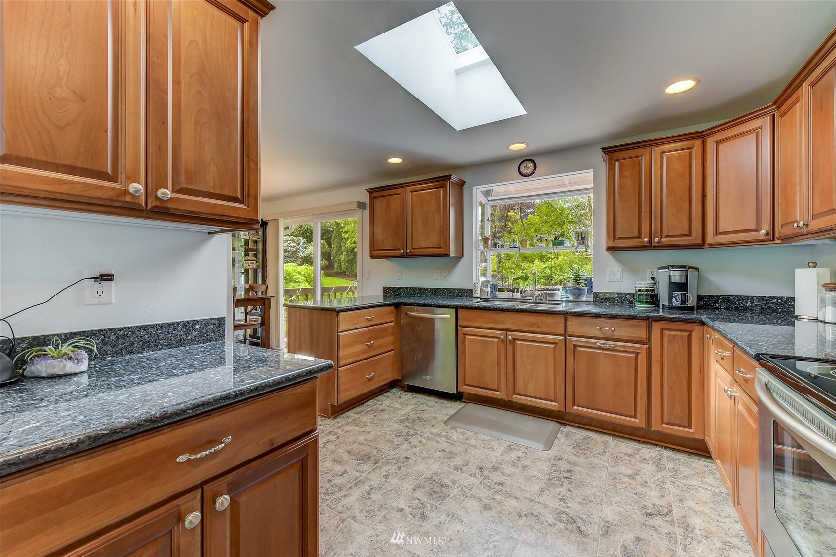 22028 5th Avenue West Bothell, WA 98021 - Photo 6 of 19 a kitchen with stainless steel appliances granite countertop wooden cabinets a stove a sink and a window
