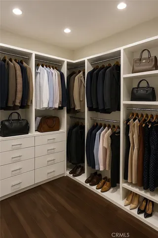 a view of walk in closet with clothes and shoes