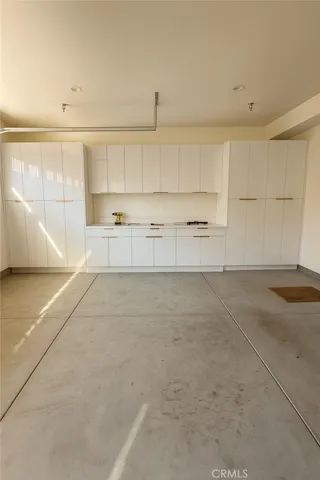 a view of a kitchen with kitchen island white cabinets and wooden floor