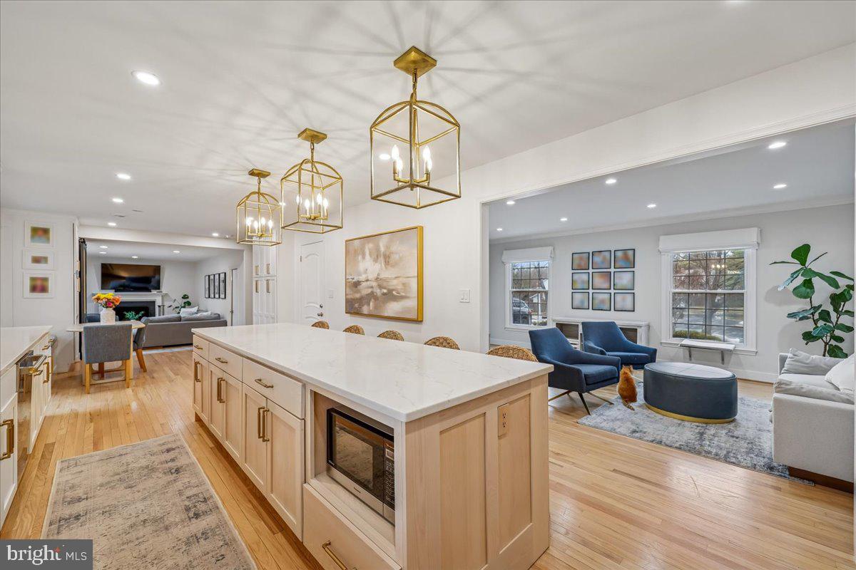 4 Olmstead Court Potomac, MD 20854 - Photo 11 of 48 a large kitchen with stainless steel appliances kitchen island granite countertop a stove a sink a dining table and chairs with wooden floor