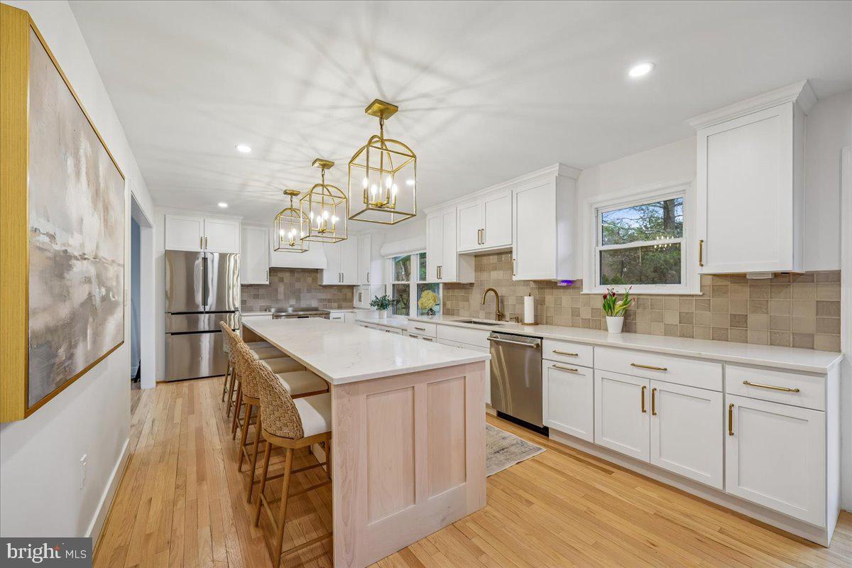 4 Olmstead Court Potomac, MD 20854 - Photo 16 of 48 a kitchen with kitchen island granite countertop a sink a counter top space appliances and cabinets