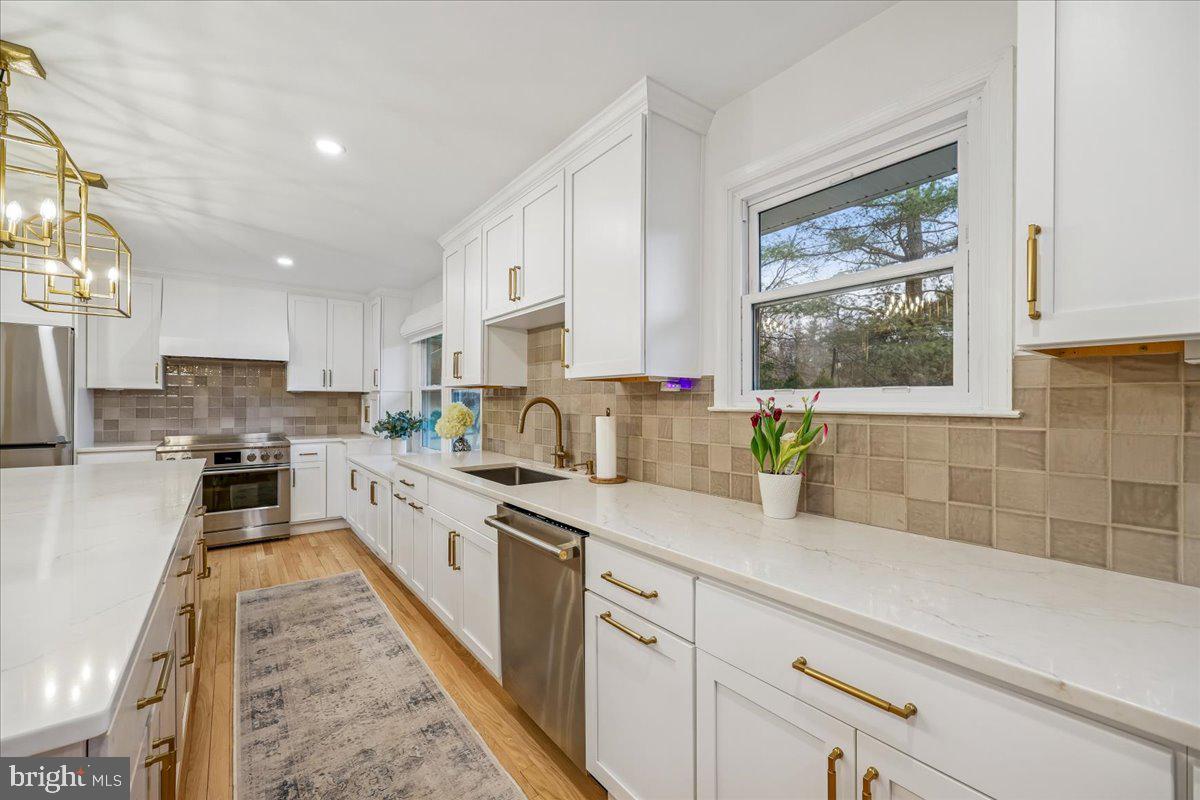 4 Olmstead Court Potomac, MD 20854 - Photo 19 of 48 a large kitchen with stainless steel appliances granite countertop a lot of counter space and a window