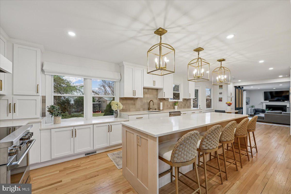 4 Olmstead Court Potomac, MD 20854 - Photo 10 of 48 a large kitchen with stainless steel appliances a center island a stove a table and chairs in it
