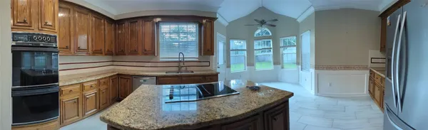 a kitchen with kitchen island granite countertop a sink and a stove