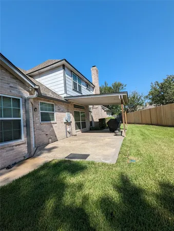a view of a house with a yard and sitting area
