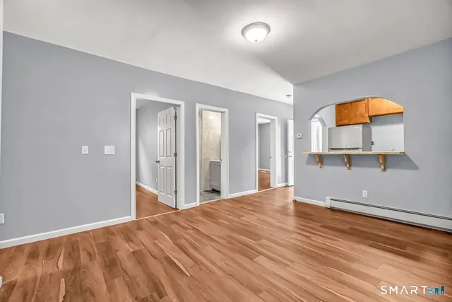 an empty room with a window and wooden floor