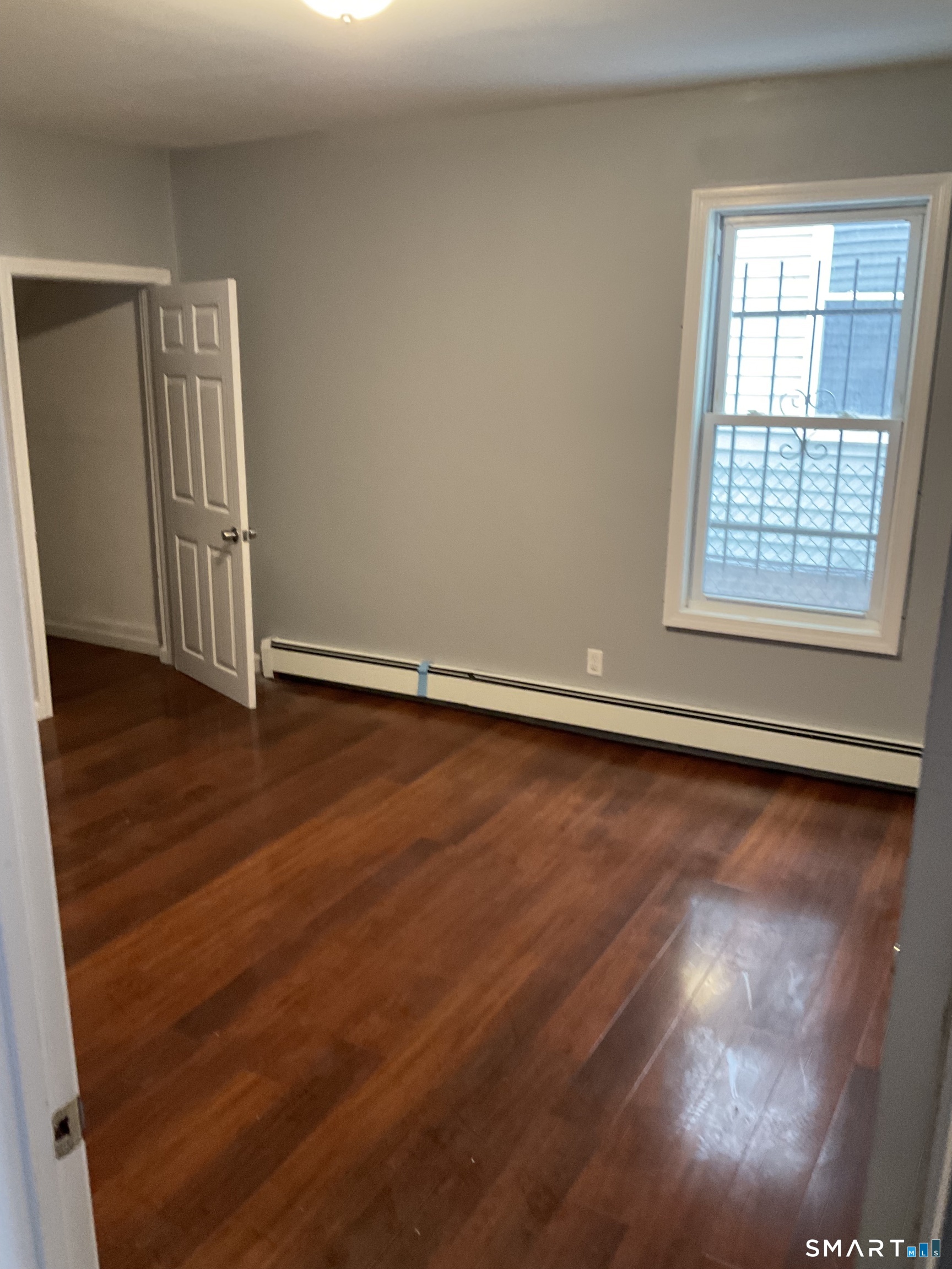 589 Winchester Avenue, Unit 3 New Haven, CT 06511 - Photo 7 of 11 an empty room with wooden floor and windows