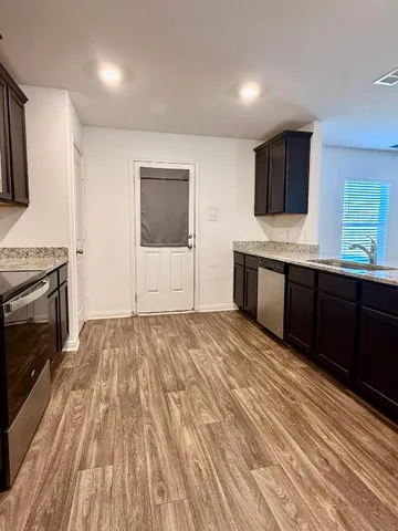 a kitchen with stainless steel appliances kitchen island granite countertop wood cabinets and granite counter tops