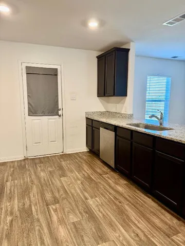a large white kitchen with stainless steel appliances granite countertop a stove and a sink