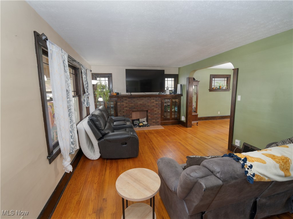 6021 Snow Road Parma, OH 44129 - Photo 4 of 28 Living room featuring plenty of natural light, light wood finished floors, and a decorative fireplace
