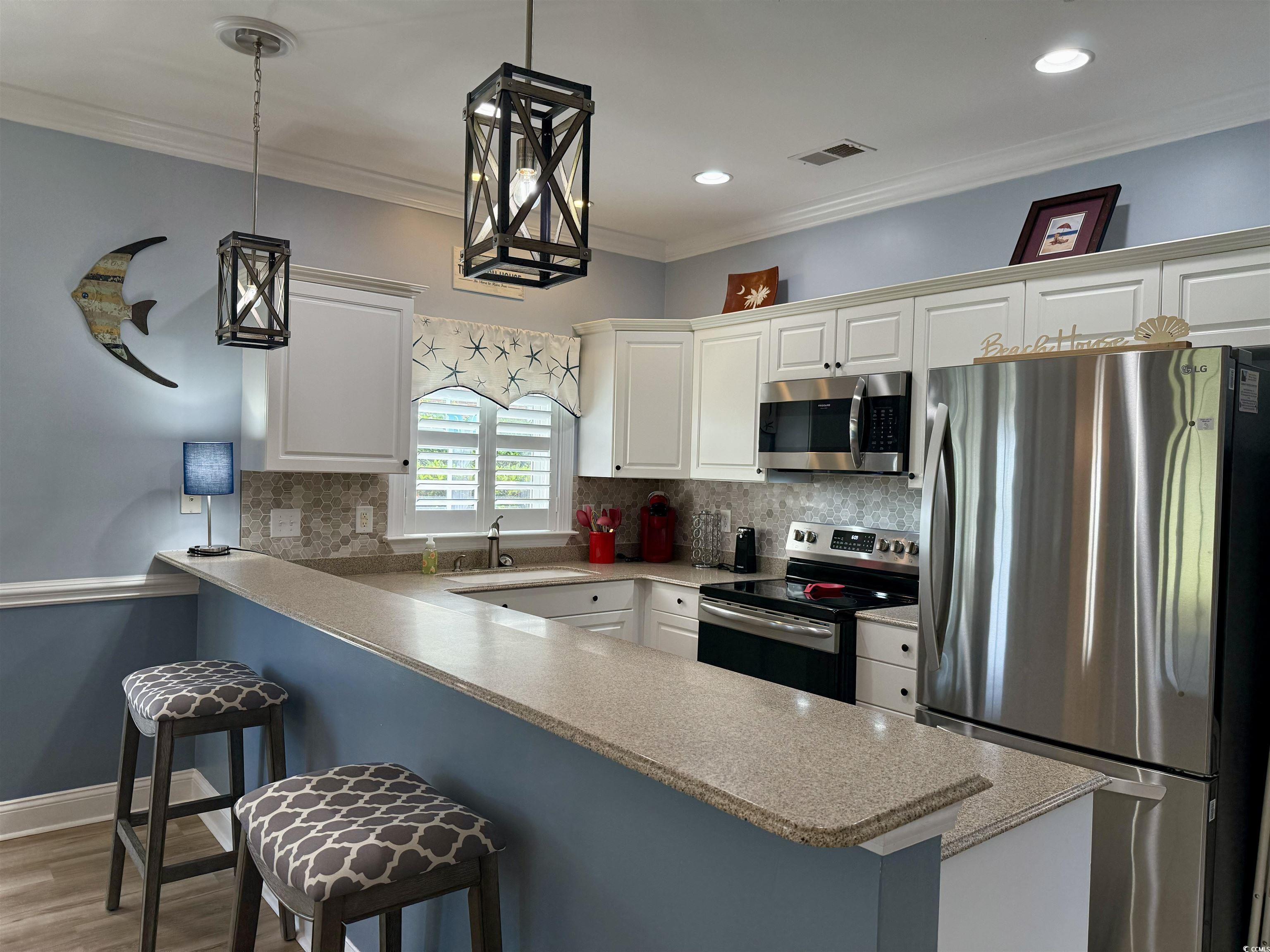 1008 Ray Costin Way, Unit 305 Murrells Inlet, SC 29576 - Photo 12 of 31 Kitchen with white cabinetry, appliances with stai