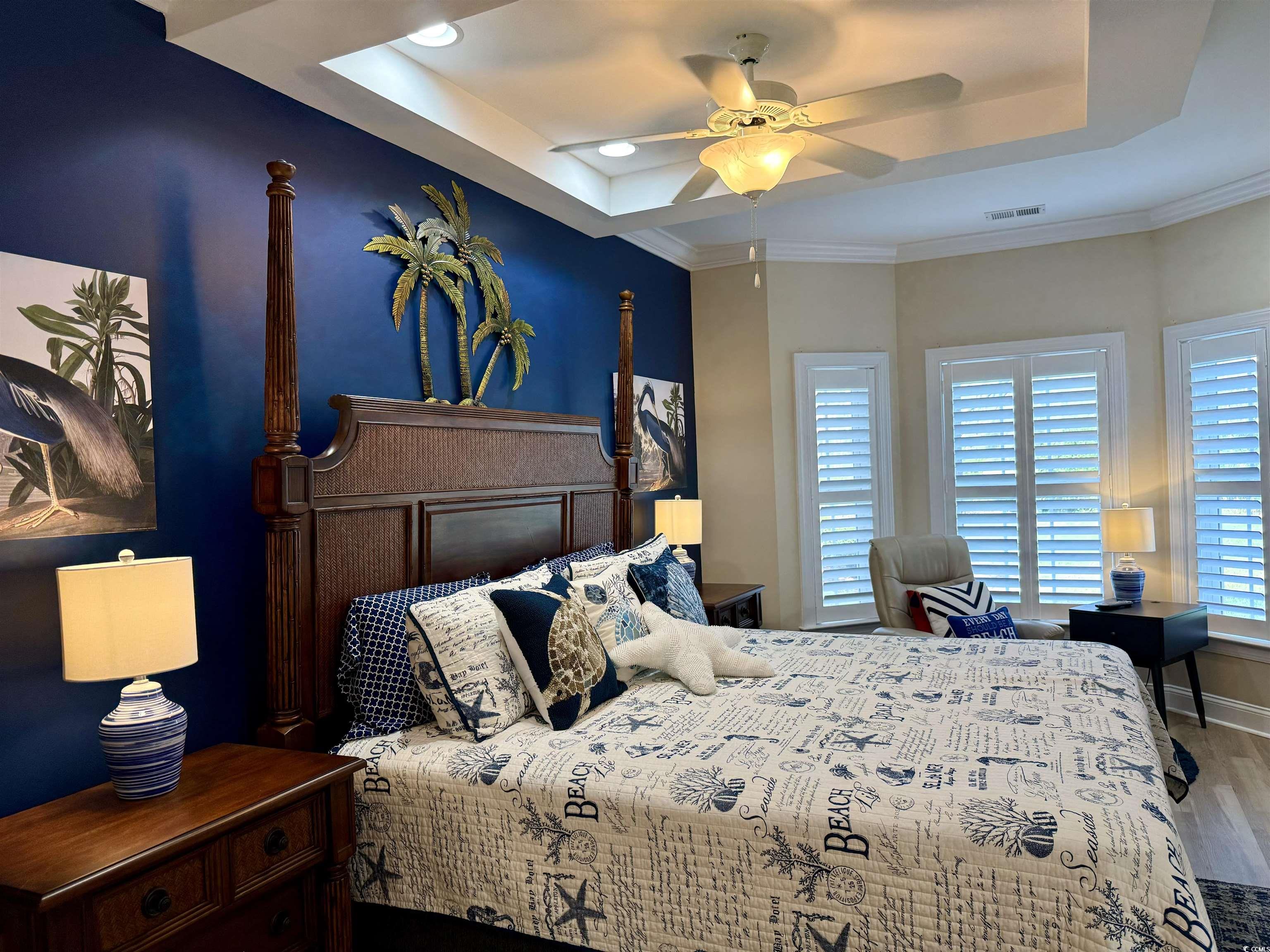 1008 Ray Costin Way, Unit 305 Murrells Inlet, SC 29576 - Photo 21 of 31 Bedroom with crown molding, a tray ceiling, wood-t