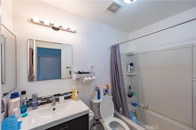 a bathroom with a sink toilet vanity mirror and shower