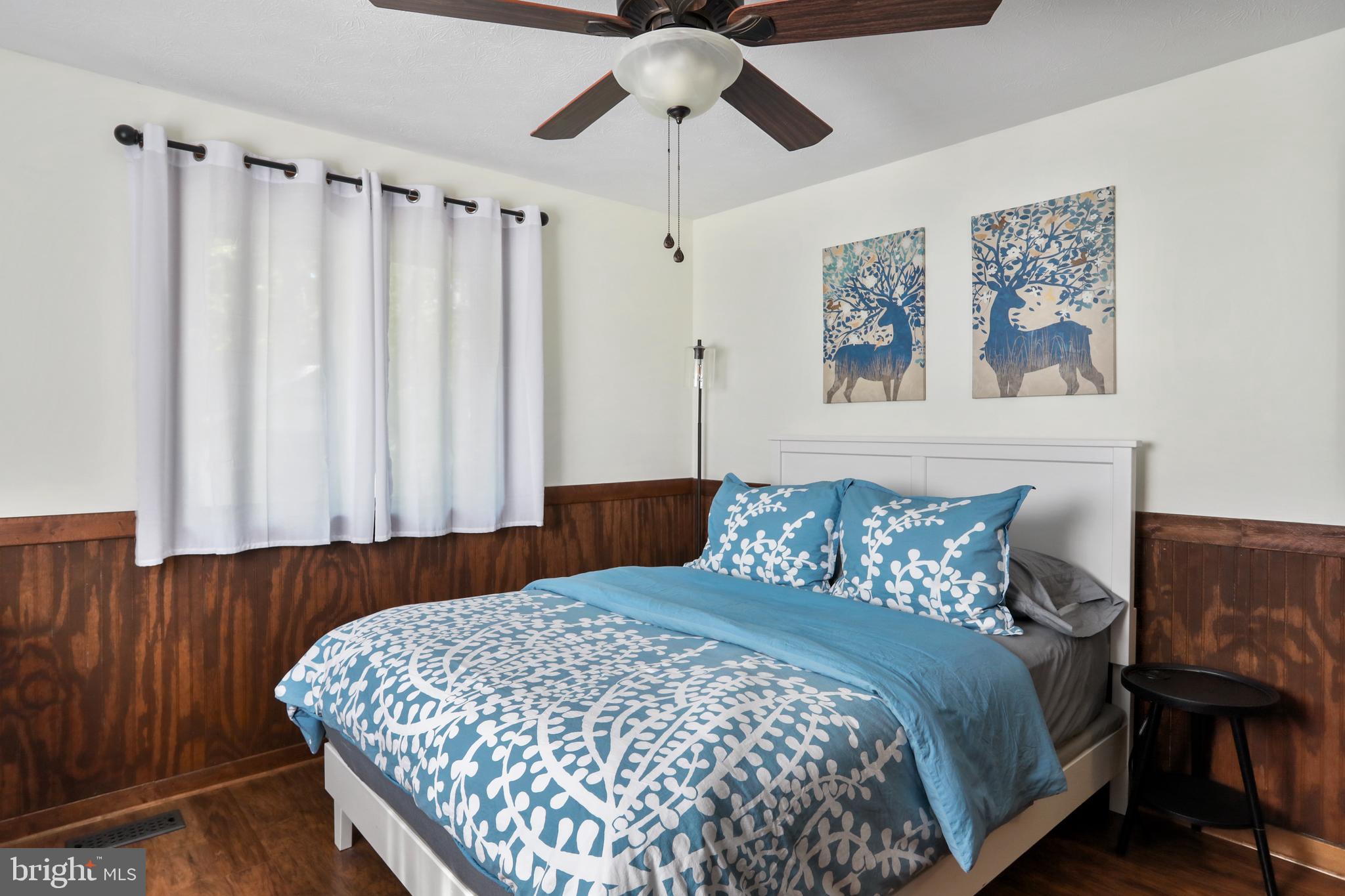 8249 Supinlick Ridge Road Mount Jackson, VA 22842 - Photo 33 of 40 a bedroom with a large bed and a chandelier